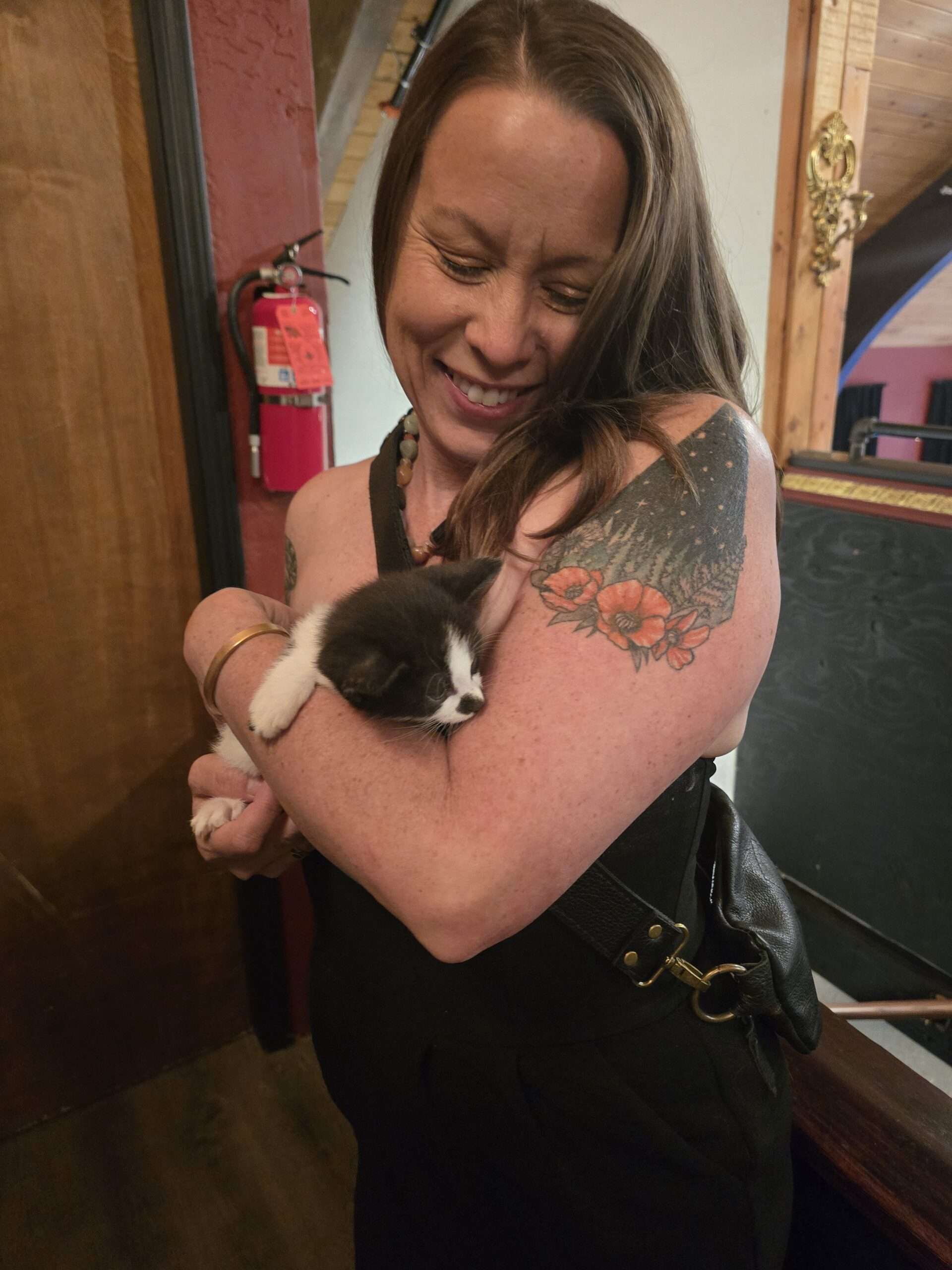 A guest holding a tuxedo kitten available for adoption at the gala